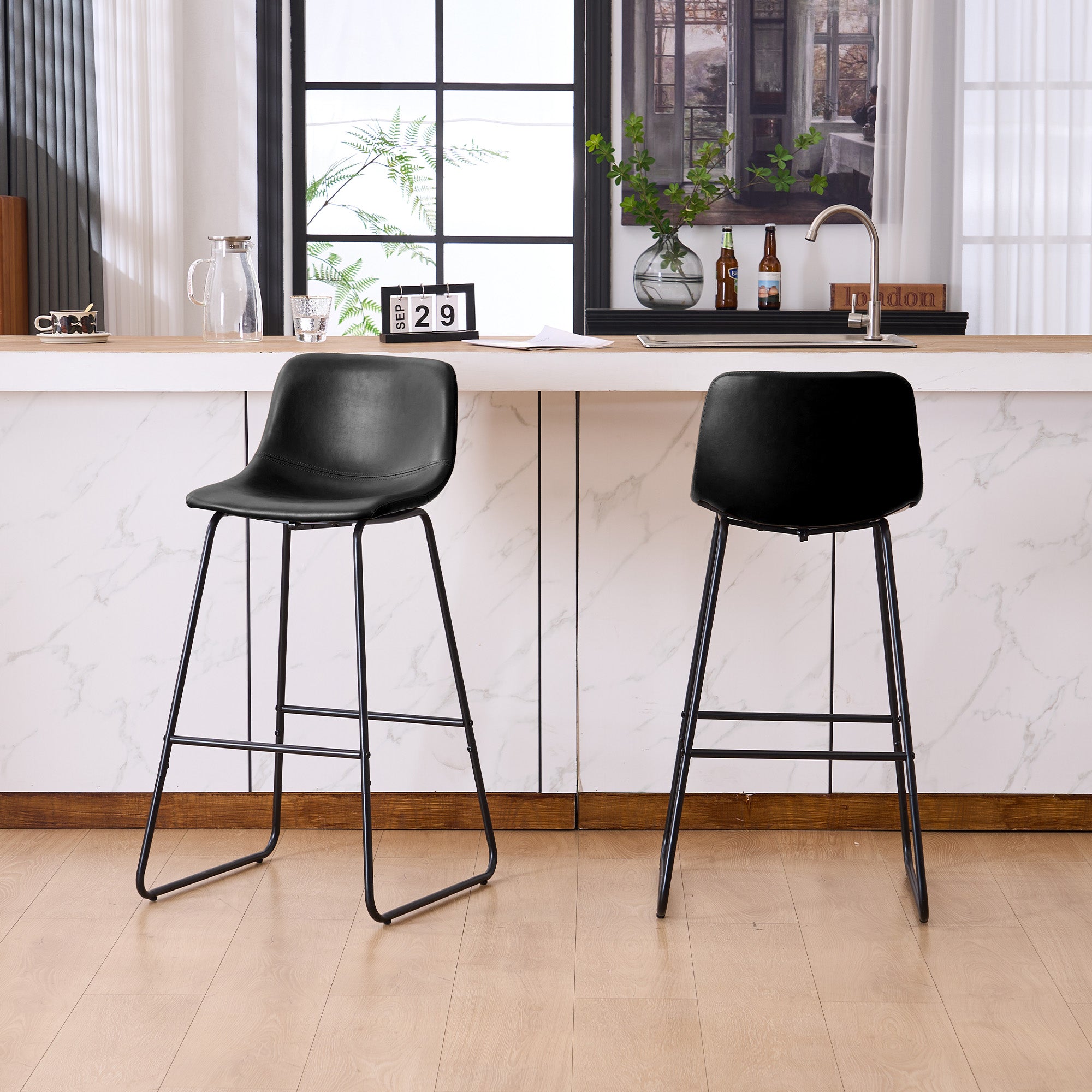Set of 2 black counter and bar height stools styled at a kitchen island with modern decor
