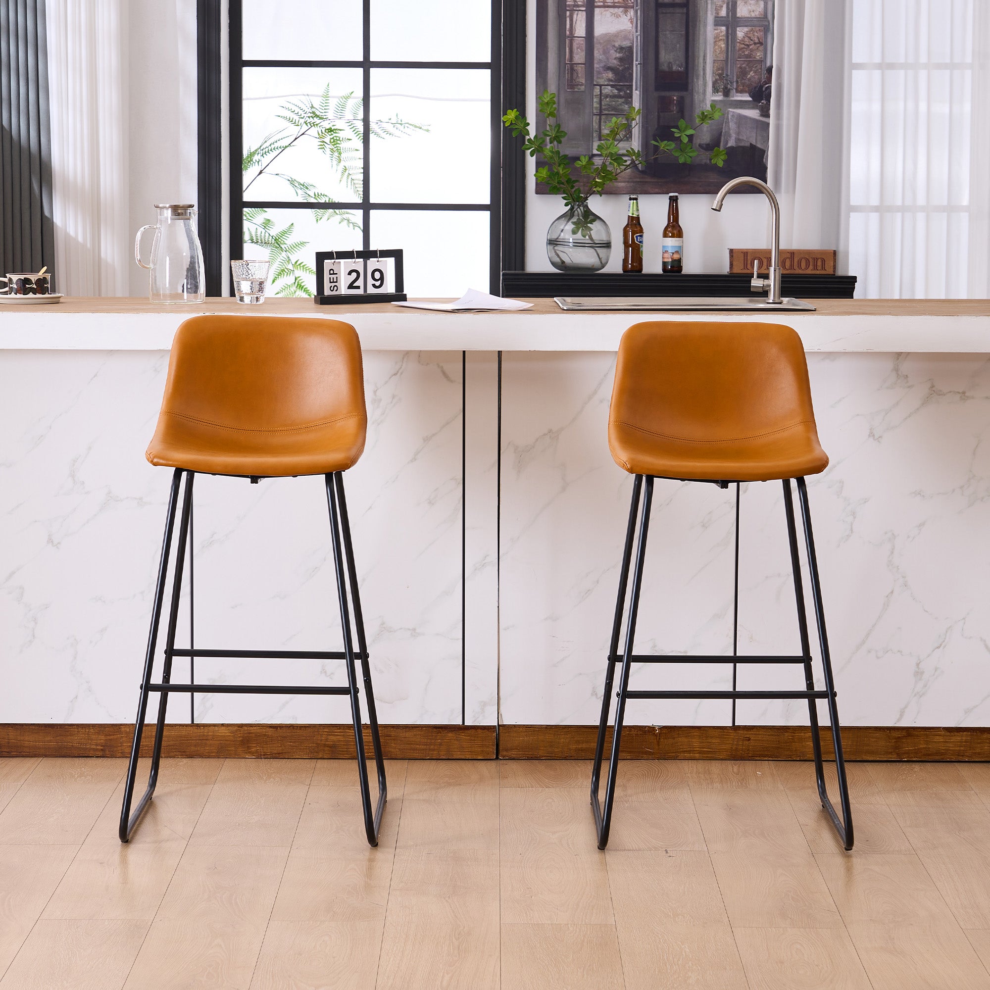 Set of 2 brown counter and bar height stools styled at a kitchen island with modern decor