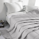 Lightweight light gray down blanket with 100% cotton cover and box quilting, featuring contrast piping and breathable comfort for year-round use