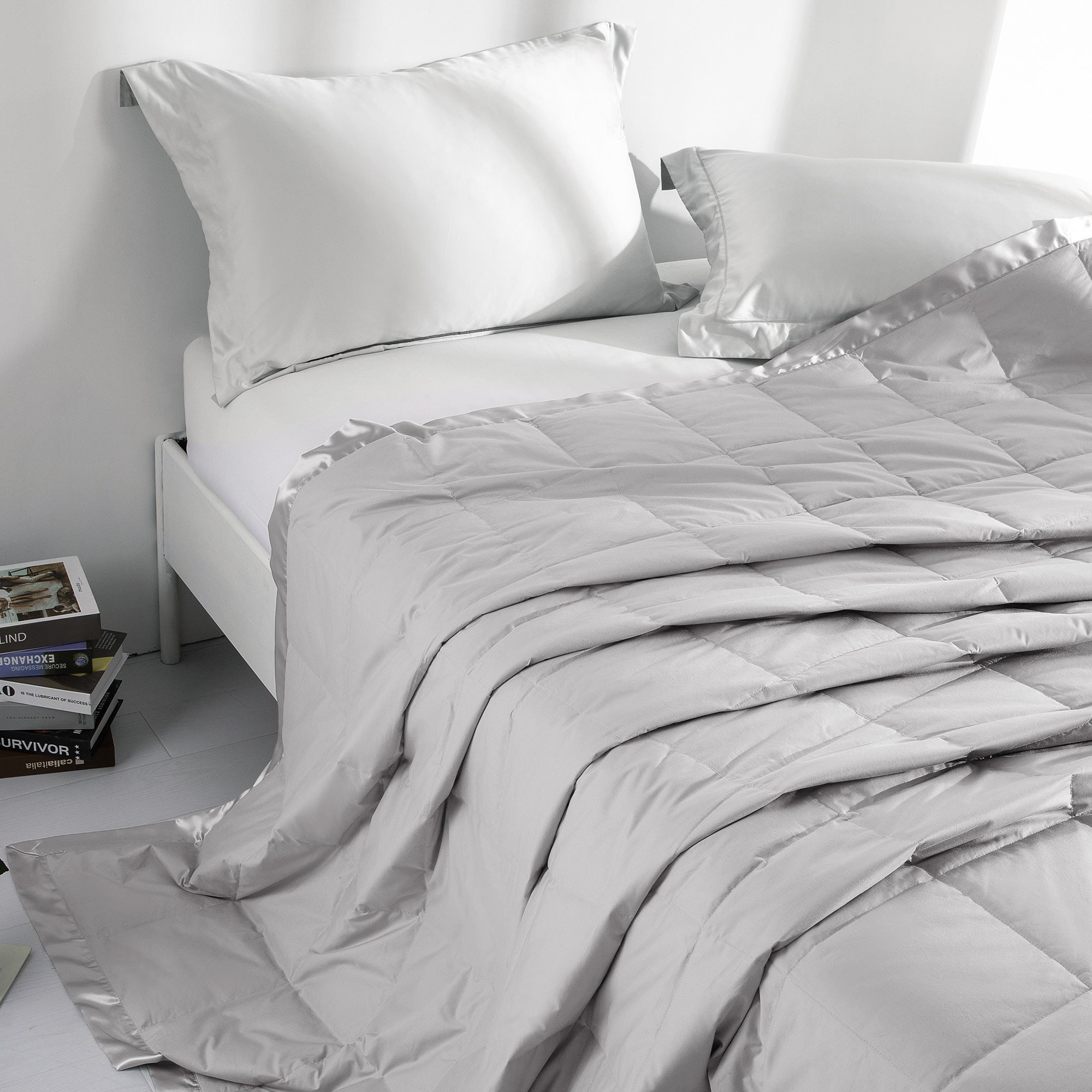 Lightweight light gray down blanket with 100% cotton cover and box quilting, featuring contrast piping and breathable comfort for year-round use