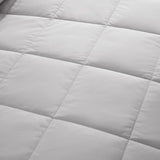 Lightweight light gray down blanket with 100% cotton cover and box quilting, featuring contrast piping and breathable comfort for year-round use