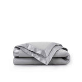 Lightweight light gray down blanket with 100% cotton cover and box quilting, featuring contrast piping and breathable comfort for year-round use