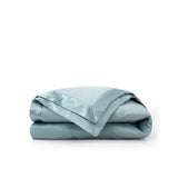 Lightweight winter sky down blanket with 100% cotton cover and box quilting, featuring contrast piping and breathable comfort for year-round use