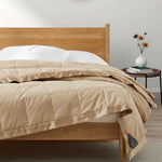 Lightweight pearled ivory down blanket with 100% cotton cover and box quilting, featuring contrast piping and breathable comfort for year-round use