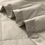 Lightweight vintaged khaki down blanket with 100% cotton cover and box quilting, featuring contrast piping and breathable comfort for year-round use