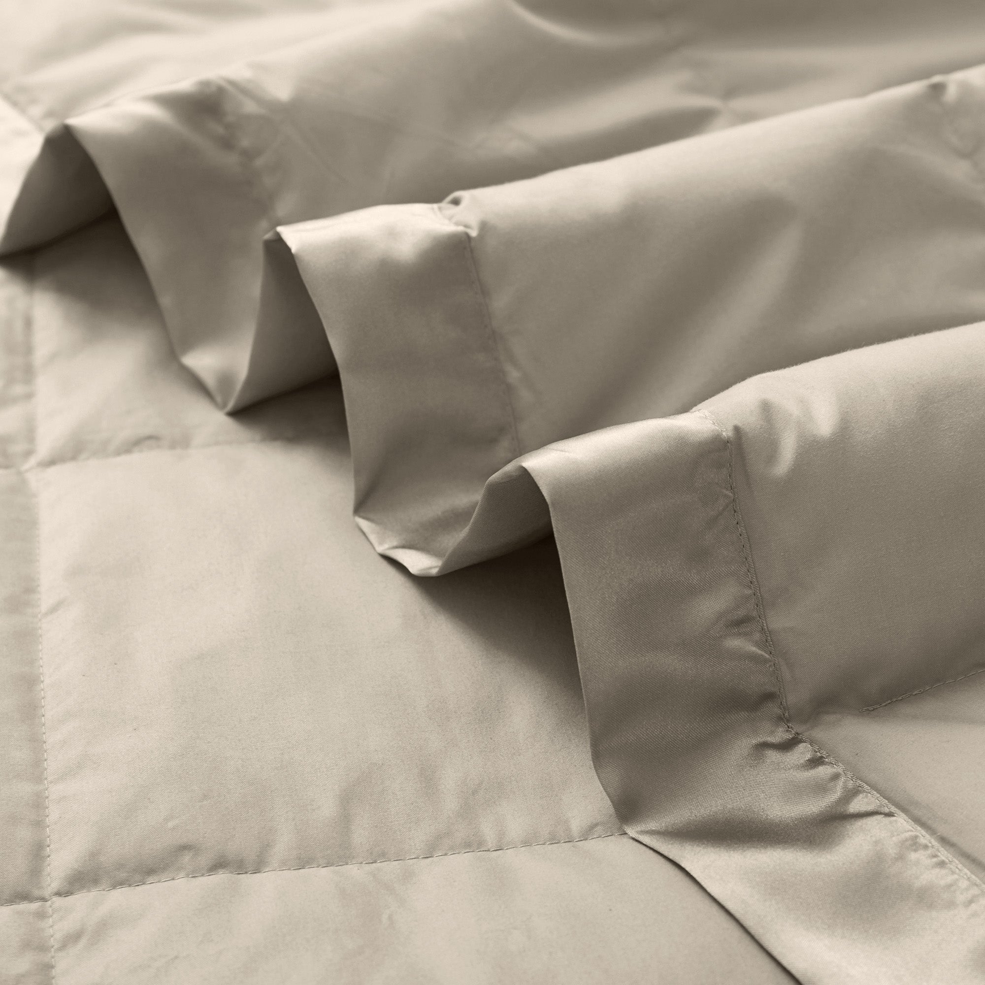 Lightweight vintaged khaki down blanket with 100% cotton cover and box quilting, featuring contrast piping and breathable comfort for year-round use