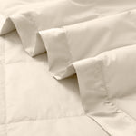 Lightweight caramel beige down blanket with 100% cotton cover and box quilting, featuring contrast piping and breathable comfort for year-round use