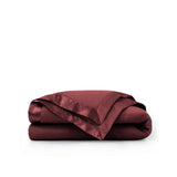 Lightweight wine red down blanket with 100% cotton cover and box quilting, featuring contrast piping and breathable comfort for year-round use