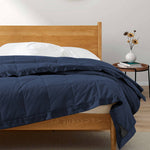 Lightweight navy down blanket with 100% cotton cover and box quilting, featuring contrast piping and breathable comfort for year-round use