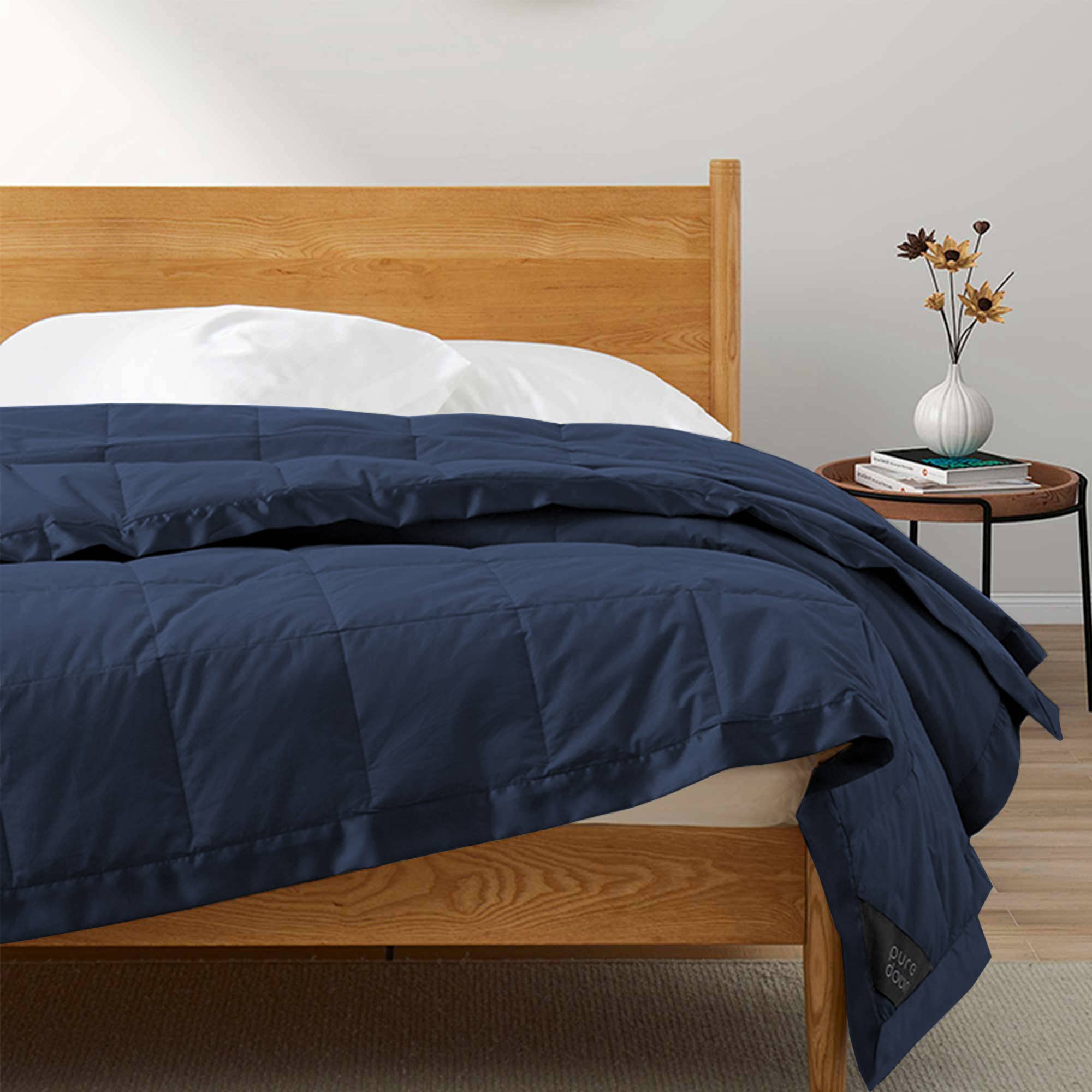 Lightweight navy down blanket with 100% cotton cover and box quilting, featuring contrast piping and breathable comfort for year-round use