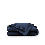 Lightweight navy down blanket with 100% cotton cover and box quilting, featuring contrast piping and breathable comfort for year-round use