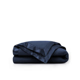 Lightweight navy down blanket with 100% cotton cover and box quilting, featuring contrast piping and breathable comfort for year-round use