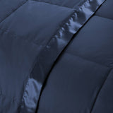Lightweight navy down blanket with 100% cotton cover and box quilting, featuring contrast piping and breathable comfort for year-round use