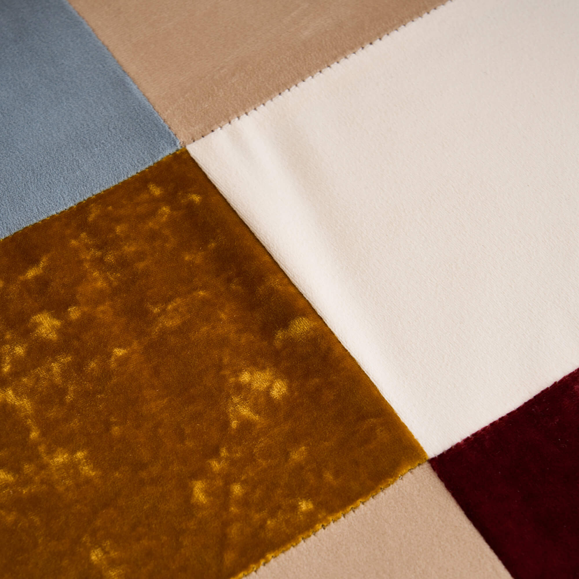 Detailed view of jacquard patchwork fabric with multicolor panels on accent chair upholstery