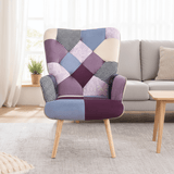 Purple and blue patchwork accent armchair styled in a cozy living room with wooden legs