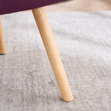 Close-up of solid wood chair leg with natural finish on patchwork accent armchair