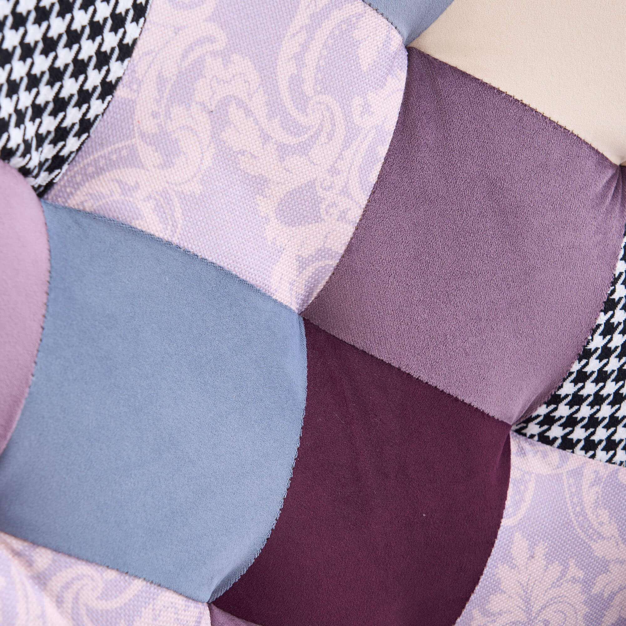 Detailed view of purple and blue jacquard patchwork fabric panels on accent chair upholstery